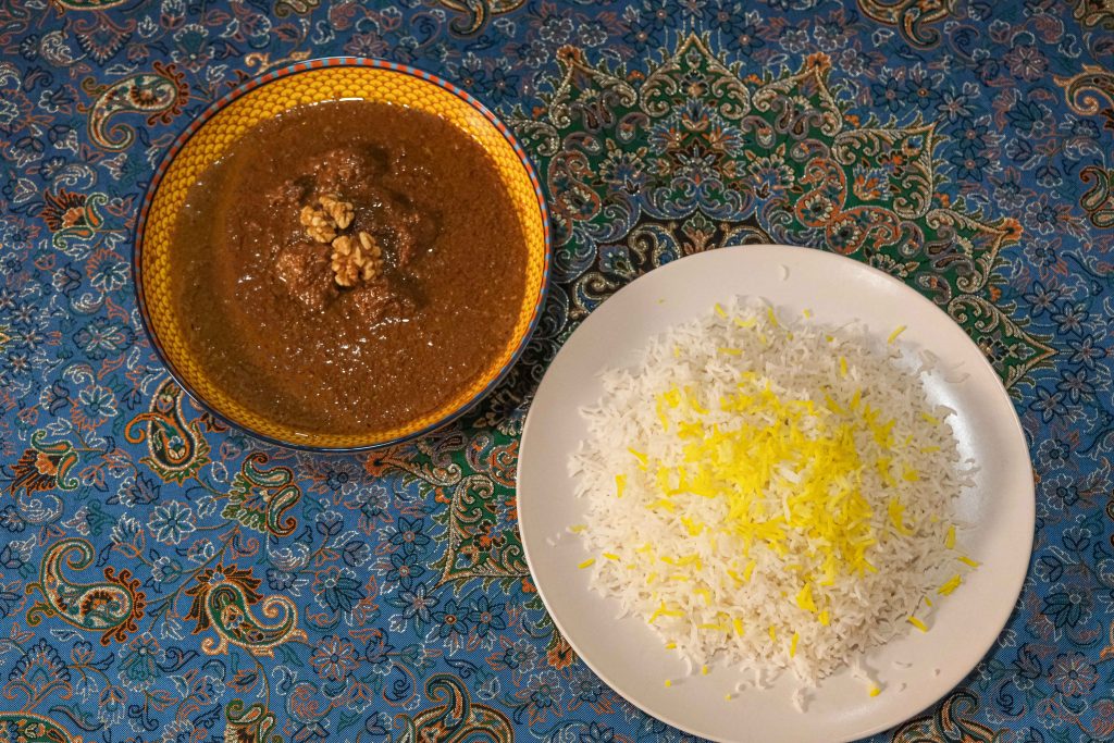 Fesenjan tradicional persa con nueces y granada servido con arroz en restaurante persa en Madrid