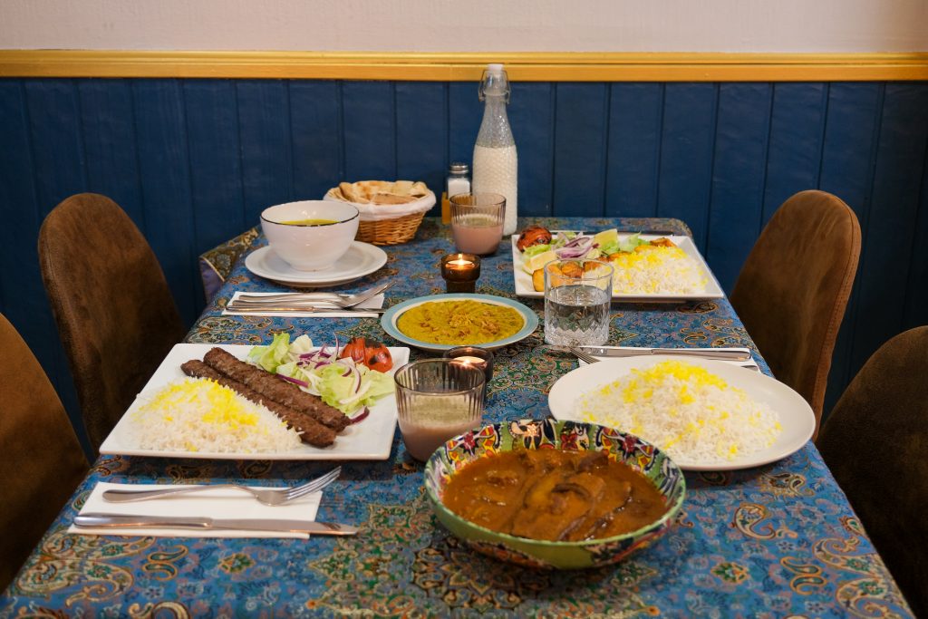 Platos tradicionales de la cocina persa y Halal en PARSI Madrid: Kebab koobideh, guisos iraníes y arroz con azafrán servidos en un ambiente persa auténtico.