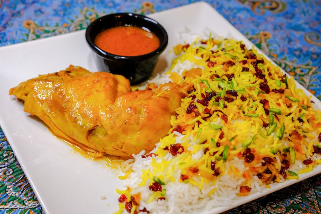 Zereshk Polo ba Morgh: Saffron-infused basmati rice with tart barberries and tender chicken at PARSI Madrid.